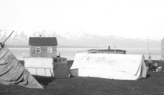 Á Sunnuhvolstúninu. Tjöld og  vörubílsboddý sem hýsti fjölskyldu Kristjáns Jóhannessonar í Brekku. Húsin eru f.v. Brekka,  Sólgarðar og Garðar