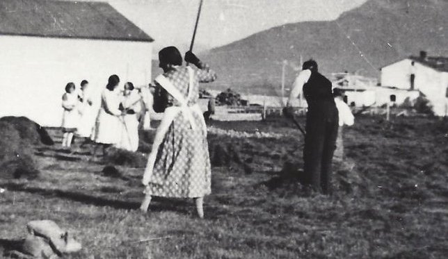 Tekið saman hey á Kaupfélagstúninu.  Jóhanna Þorleifsdóttir  og Jón H. Lyngstað í Ártúni fremst á myndinni. Húsið í baksýn er Barcelona, pakkhús í eigu kaupfélagsins. Myndin er tekin um 1940.  (1930 – 1940)