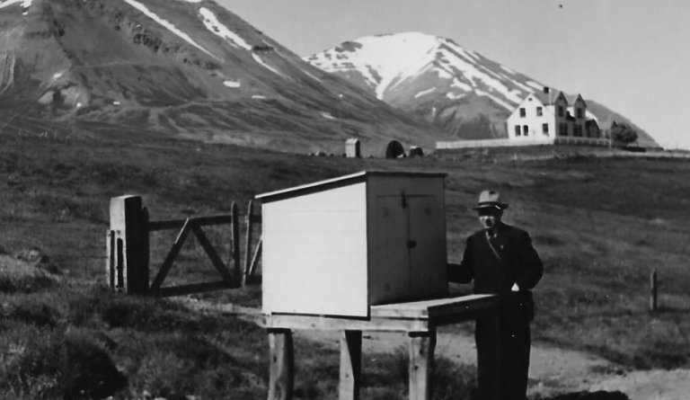 Brúsapallur við Hrafnsstaðakot í Svarfaðardal 1948. Magnús Jónsson bóndi stendur við pallinn. Bærinn á Hrafnsstöðum í baksýn.